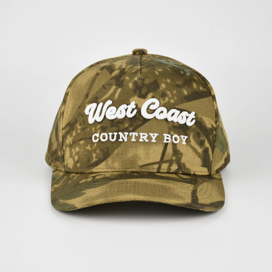 A camouflage baseball cap with 'West Coast COUNTRY BOY' embroidered in white on the front, set against a plain light gray background.
