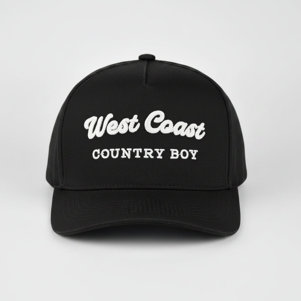 A black baseball cap with 'West Coast COUNTRY BOY' embroidered in white on the front, set against a light gray studio background.
