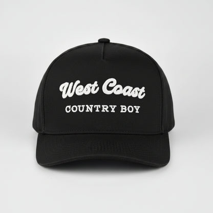 A black baseball cap with 'West Coast COUNTRY BOY' embroidered in white on the front, set against a light gray studio background.