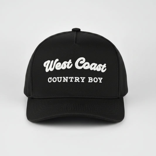 A black baseball cap with 'West Coast COUNTRY BOY' embroidered in white on the front, set against a light gray studio background.