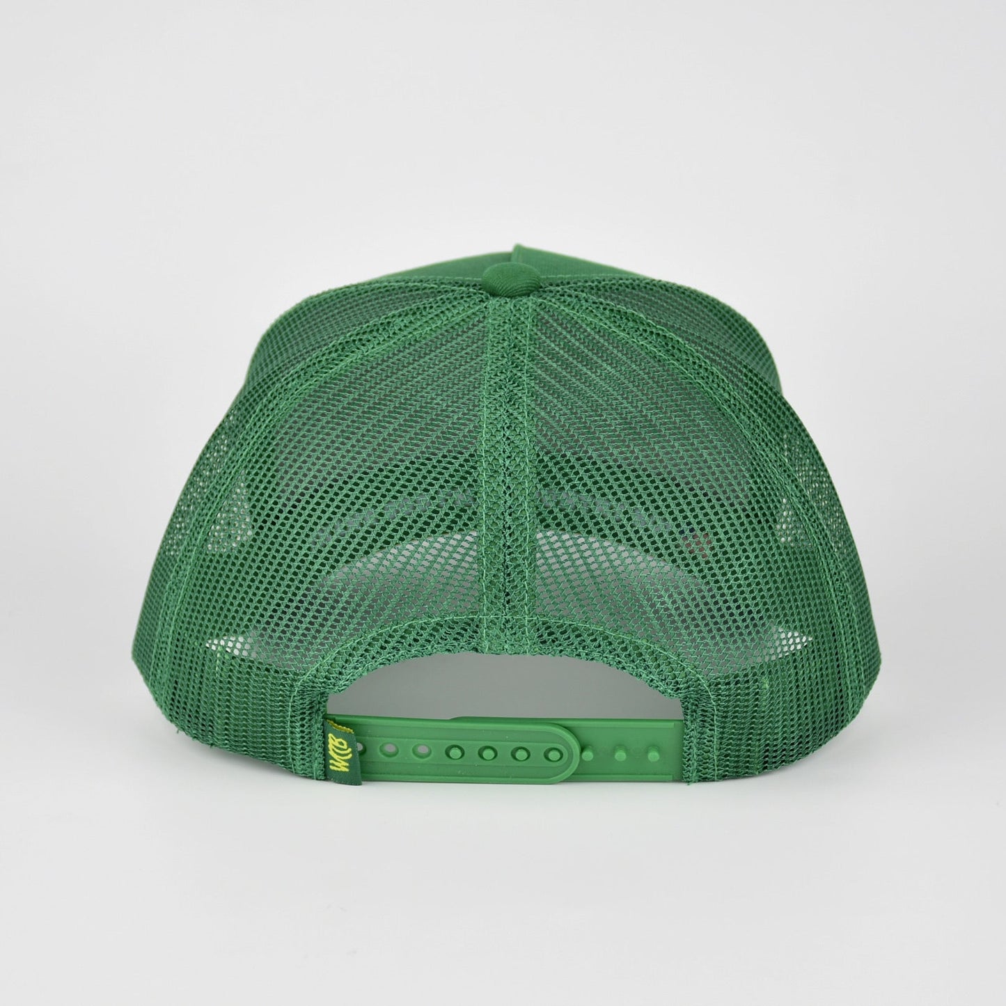 A green mesh-back trucker cap shown from the back, featuring a green mesh back and an adjustable snap closure with WCCB label, photographed against a light gray studio background.